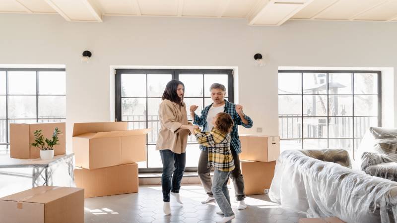 Family relaxing among moving boxes in a new home